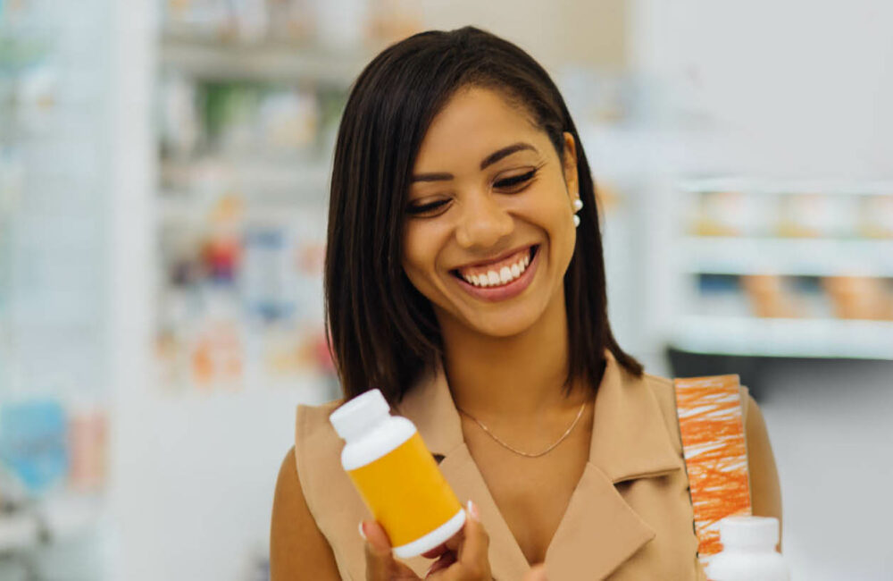 Woman Smiling while looking at pill bottle